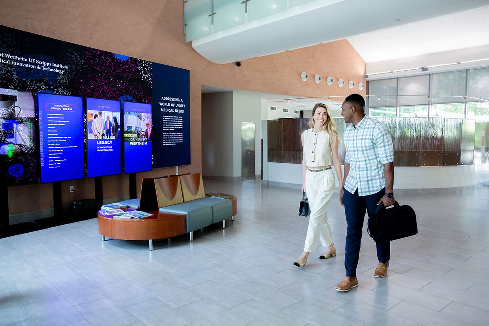Two professionals walking through a bright office lobby